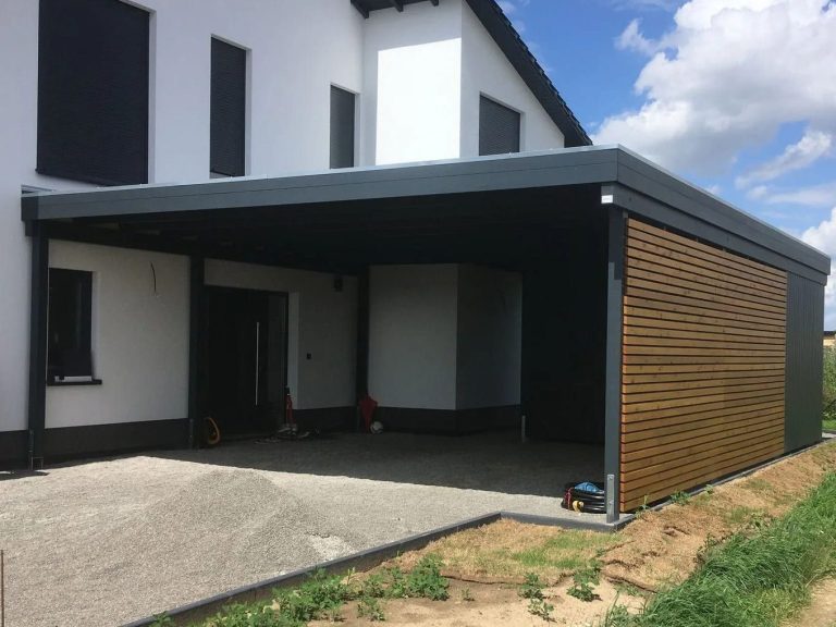 Doppelcarport in Anthrazit mit Schuppen und seitlicher Rhombusverkleidung im Kreis Vechelde Ein modernes Haus mit einem überdachten Bereich und Holzverkleidung an einer Wand.